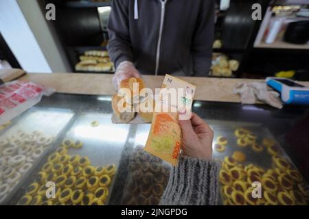 Buenos Aires, Argentinien. 10. August 2022. Eine Frau zahlt mit einer Rechnung von 1000 Peso in einer Bäckerei. (To dpa 'Inflationsrate in Argentinien steigt auf 71 Prozent') Kredit: Claudio Santisteban/dpa/Alamy Live News Stockfoto