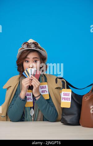 Aufgeregt shopaholic Frau hält viele Kreditkarten auf blauem Hintergrund Stockfoto