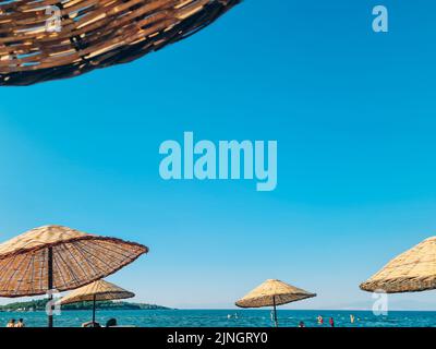 Bambus-Sonnenschirm auf blauem Himmel Hintergrund Stockfoto