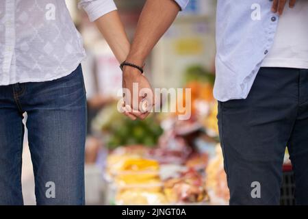 Nicht erkennbares interrassisches Paar, das die Hände im Freien hält Stockfoto