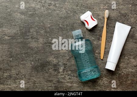 Mundspülung und andere Mundhygiene-Produkte auf farbiger Tischansicht mit Kopierfläche. Flach liegend. Zahnhygiene. Mundpflegeprodukte und Platz für Text o Stockfoto