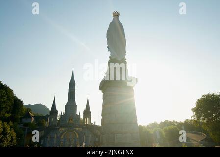 Sonnenuntergang in Sanctuaires Notre-Dame de Lourdes, einem katholischen Wallfahrtsort in Südfrankreich. Das Heiligtum unserer Lieben Frau von Lourdes. Kirche. Schreinstatue. Stockfoto