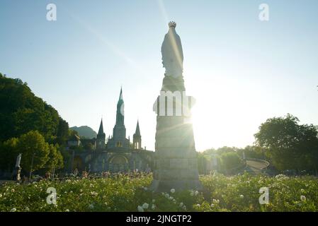 Sonnenuntergang in Sanctuaires Notre-Dame de Lourdes, einem katholischen Wallfahrtsort in Südfrankreich. Das Heiligtum unserer Lieben Frau von Lourdes. Kirche. Schreinstatue. Stockfoto