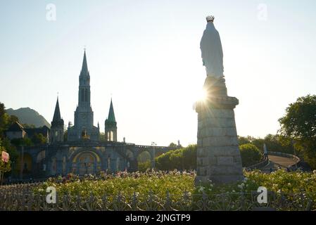 Sonnenuntergang in Sanctuaires Notre-Dame de Lourdes, einem katholischen Wallfahrtsort in Südfrankreich. Das Heiligtum unserer Lieben Frau von Lourdes. Kirche. Schreinstatue. Stockfoto