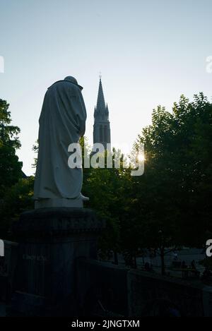 Sonnenuntergang in Sanctuaires Notre-Dame de Lourdes, einem katholischen Wallfahrtsort in Südfrankreich. Das Heiligtum unserer Lieben Frau von Lourdes. Kirche. Schreinstatue. Stockfoto