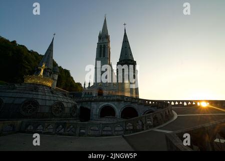 Sonnenuntergang in Sanctuaires Notre-Dame de Lourdes, einem katholischen Wallfahrtsort in Südfrankreich. Das Heiligtum unserer Lieben Frau von Lourdes. Kirche. Schrein. Stockfoto