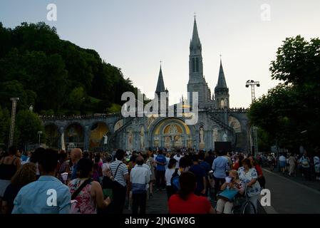 Menschen versammelten sich @ Sanctuaires Notre-Dame de Lourdes Eine katholische Pilgerfahrt. Nächtliche Kerzenschein-Messe-Wallfahrtskirche unserer Lieben Frau von Lourdes. Lourdes-Prozession. Stockfoto