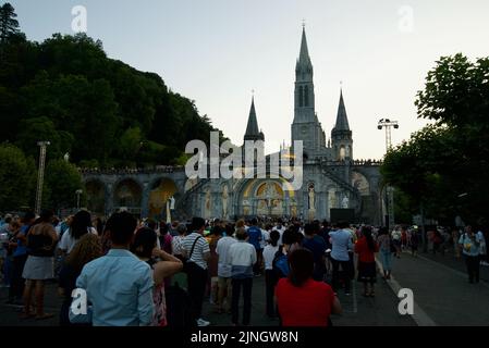 Menschen versammelten sich @ Sanctuaires Notre-Dame de Lourdes Eine katholische Pilgerfahrt. Nächtliche Kerzenschein-Messe-Wallfahrtskirche unserer Lieben Frau von Lourdes. Lourdes-Prozession. Stockfoto