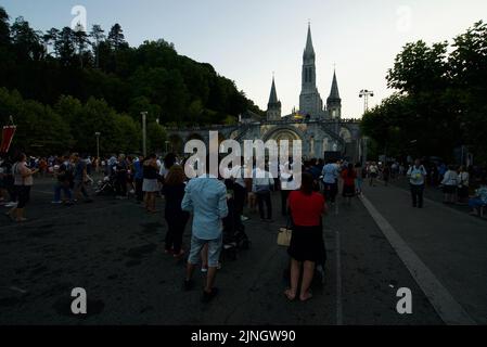 Menschen versammelten sich @ Sanctuaires Notre-Dame de Lourdes Eine katholische Pilgerfahrt. Nächtliche Kerzenschein-Messe-Wallfahrtskirche unserer Lieben Frau von Lourdes. Lourdes-Prozession. Stockfoto