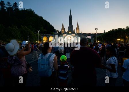 Menschen versammelten sich @ Sanctuaires Notre-Dame de Lourdes Eine katholische Pilgerfahrt. Nächtliche Kerzenschein-Messe-Wallfahrtskirche unserer Lieben Frau von Lourdes. Lourdes-Prozession. Stockfoto