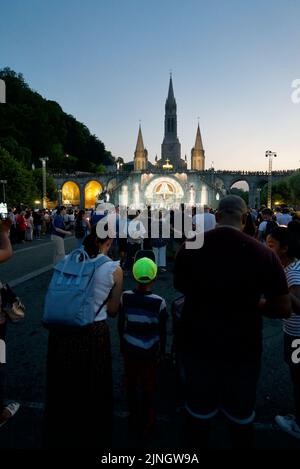 Menschen versammelten sich @ Sanctuaires Notre-Dame de Lourdes Eine katholische Pilgerfahrt. Nächtliche Kerzenschein-Messe-Wallfahrtskirche unserer Lieben Frau von Lourdes. Lourdes-Prozession. Stockfoto