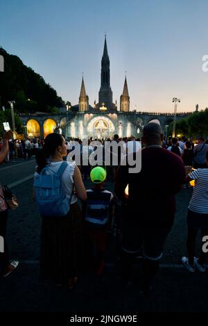 Menschen versammelten sich @ Sanctuaires Notre-Dame de Lourdes Eine katholische Pilgerfahrt. Nächtliche Kerzenschein-Messe-Wallfahrtskirche unserer Lieben Frau von Lourdes. Lourdes-Prozession. Stockfoto