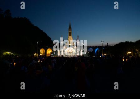 Menschen versammelten sich @ Sanctuaires Notre-Dame de Lourdes Eine katholische Pilgerfahrt. Nächtliche Kerzenschein-Messe-Wallfahrtskirche unserer Lieben Frau von Lourdes. Lourdes-Prozession. Stockfoto