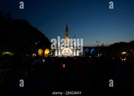 In der Nacht versammelten sich Menschen in Sanctuaires Notre-Dame de Lourdes. Ein katholischer Wallfahrtsort. Kerzenschein-Messe @ Wallfahrtskirche unserer Lieben Frau von Lourdes. Nacht. Stockfoto