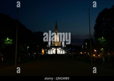 In der Nacht versammelten sich Menschen in Sanctuaires Notre-Dame de Lourdes. Ein katholischer Wallfahrtsort. Kerzenschein-Messe @ Wallfahrtskirche unserer Lieben Frau von Lourdes. Nacht. Stockfoto