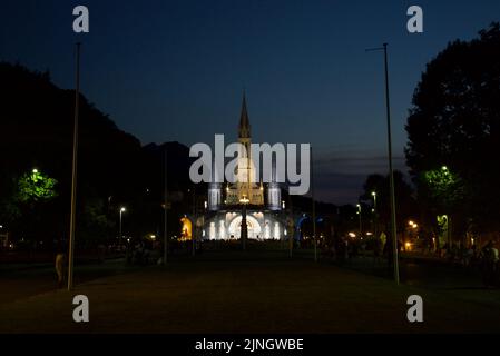 In der Nacht versammelten sich Menschen in Sanctuaires Notre-Dame de Lourdes. Ein katholischer Wallfahrtsort. Kerzenschein-Messe @ Wallfahrtskirche unserer Lieben Frau von Lourdes. Nacht. Stockfoto