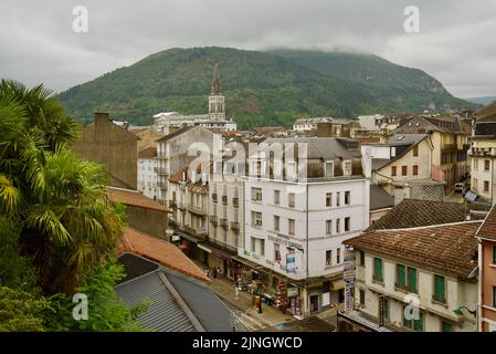 Ein Blick von oben auf die französische Stadt Lourdes, Südfrankreich, in den Hautes-Pyrénées Oczitanie. Berge und Église Paroissiale de Lourdes. Stockfoto