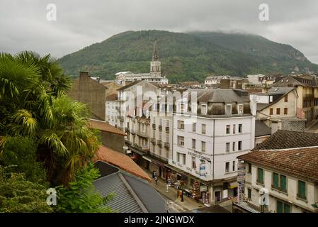 Ein Blick von oben auf die französische Stadt Lourdes, Südfrankreich, in den Hautes-Pyrénées Oczitanie. Berge und Église Paroissiale de Lourdes. Stockfoto