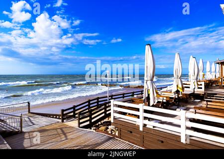 Leeres Strandcafe ohne Besucher. Böschung an einem sonnigen Tag. Leeres Resort in der Nebensaison. Zelenogradsk, Russland - 26. Mai 2022. Stockfoto
