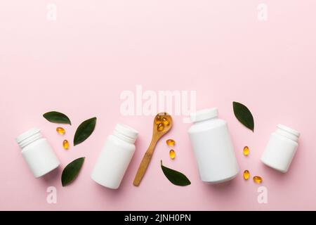 Omega-3 Kapseln liegen in einer weißen Flasche auf einem Tisch mit grünem Blatthintergrund. Fischöltabletten. Biologisch aktive Zusatzstoffe. omega 6, Omega 9, Vitam Stockfoto