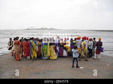 Fisher-Leute versammeln sich in der Nähe des Ozeans, um den Narali Poornima (Kokosnusstag) in Mumbai zu feiern. Die hinduistische Fischergemeinde in der Küstenregion Maharashtra bietet Kokosnüsse an und betet zum Meer für eine sichere Angelsaison. Singen und Tanzen ist das Hauptereignis während der Feier zusammen mit der Zubereitung von süßem Kokosnussreis am Tag. Stockfoto