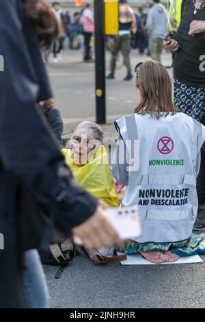 Extinction Rebellion (XR)-Aktivisten sprangen auf eine Schwarze Limousine und saßen auf dem Boden und klebten sich in Marble Arch Stockfoto