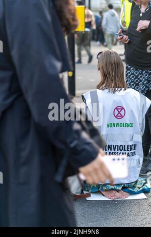 Extinction Rebellion (XR)-Aktivisten sprangen auf eine Schwarze Limousine und saßen auf dem Boden und klebten sich in Marble Arch Stockfoto