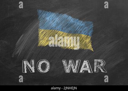 Nationalflagge der Ukraine und Schriftzug KEIN KRIEG handgezeichnet mit Kreide auf Tafel. Flagge winkt im Wind. Stehe mit der Ukraine Stockfoto