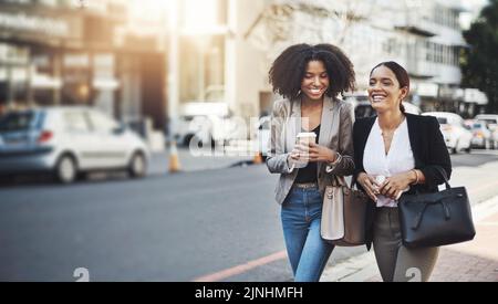 Jeder Schritt bringt sie dem großen Erfolg näher. Zwei Geschäftsfrauen gehen in der Stadt. Stockfoto