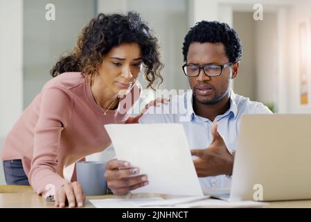 Heute haben wir unsere Finanzen sortiert. Ein junges Paar, das zu Hause gemeinsam Finanzplanung macht. Stockfoto