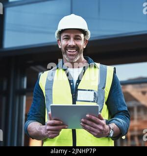 Technologie verändert die Architektur. Ein Ingenieur, der auf einer Baustelle ein digitales Tablet verwendet. Stockfoto