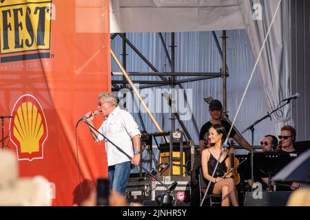 Roger Daltry singt mit einer Geigerin und Mitglieder der Louisiana Philahamonic sitzen auf der Bühne, als The Who beim New Orleans Jazzfest 2022 auftritt Stockfoto