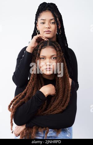 Pflegen Sie sich gegenseitig Schönheit, beobachten Sie einander wachsen. Studioaufnahme von zwei schönen jungen Frauen, die vor einem grauen Hintergrund posieren. Stockfoto