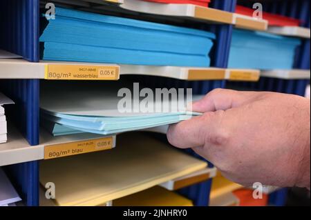 Karlsruhe, Deutschland. 08. August 2022. In einer Druckerei wird ein Stapel DIN A4 Papier gezeigt. Die berühmtesten 29,7 mal 21 Zentimeter werden 100 Jahre alt, das Format DIN A4. Am 18. August 2022, also vor genau 100 Jahren, hat das Deutsche Institut für Normung (DIN) seine Richtlinie 476 für Papierformate veröffentlicht. Seitdem sind der Typ A4 und seine Geschwister das Maß aller Dinge in Büro und Schule. Quelle: Uli Deck/dpa/Alamy Live News Stockfoto