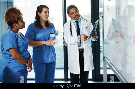 Es tut nicht weh, eine zweite oder dritte Meinung. Ein Team von Ärzten diskutieren die Ergebnisse einer Röntgenaufnahme in einem Krankenhaus. Stockfoto