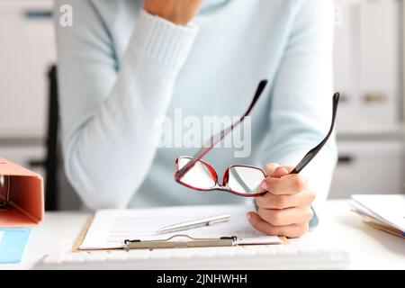 Weibliche Büroleiterin, die am Arbeitsplatz mit Dokumenten arbeitet Stockfoto