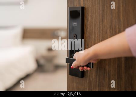 Hand, die Tür zu öffnen, hotel Schlafzimmer Tür selektiven Fokus. Stockfoto