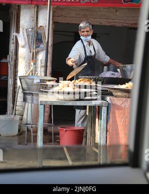 Alter Mann, der Somosa auf dem Markt verkauft Stockfoto