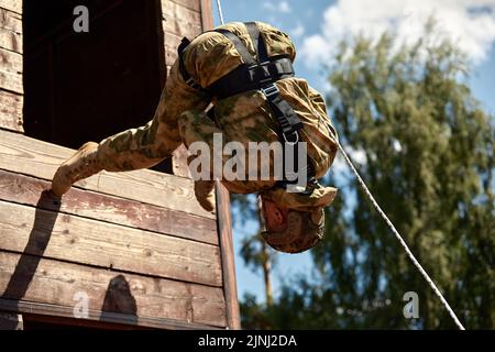 Spezialeinsatzkräfte während des Sturmabsturms mit Waffen. Soldaten abseilen Stockfoto