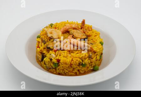 Traditionelle spanische Paella in einem weißen disch isoliert auf weißem Hintergrund. Stockfoto