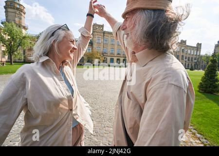 Positiv erfreut ältere Menschen, die beim Tanzen beim Gehen Spaß hatten Stockfoto
