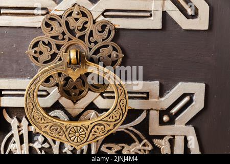 Vintage-Griff an einer alten orientalischen Holztür mit Ornamenten verziert Stockfoto