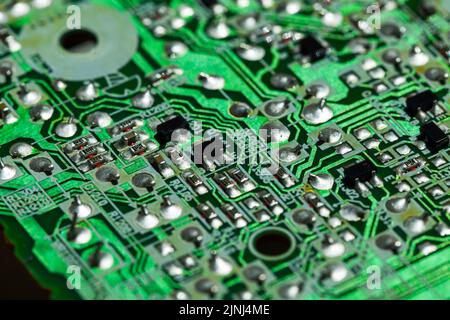 Grüne Leiterplatte, Mikroelektronik-Komponente. Makrofoto mit selektivem Weichfokus Stockfoto