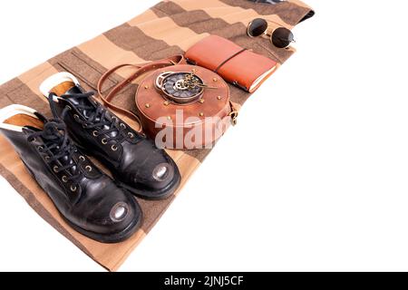 Kleidung und Accessoires flaches Lay: Circle Uhrwerk Ledertasche, vintage Arbeitsstiefel, Journal, Sonnenbrille, Kleid isoliert auf weiß. Stockfoto