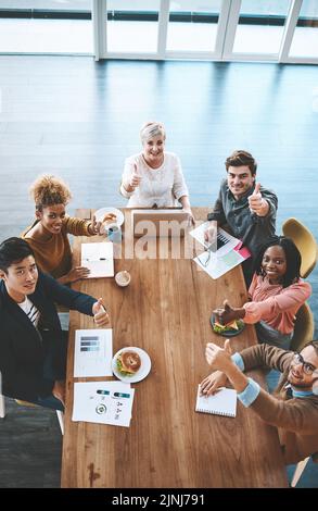 Daumen hoch bei der Mittagsbesprechung, Unterstützung und Handzeichen von professionellen Geschäftsleuten im Büro zusammen. Mitarbeiter und Kollegen suchen Stockfoto