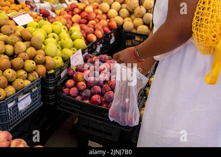 Frau wählt Obst und Gemüse auf dem Bauernmarkt, mit dem Konzept der Nullabfallvermeidung. Stockfoto