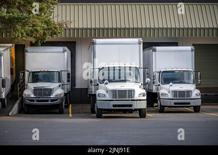 Nützlicher Industriestandard für lokale Lieferungen und Kurzstreckenfrachten kompakte Mittellastgeräte Semi-Trucks mit Boxanhänger, die im Lager d stehen Stockfoto