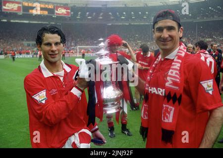 Datei-Foto vom 14-05-1994 von Ryan Giggs von Manchester United (links) und Eric Cantona, die nach dem Finale gegen Chelsea in Wembley den FA Cup halten. Am Ende der folgenden Saison waren die Blades jedoch abgestiegen und Manchester United war Back-to-Back-Champions der Premier League geworden, was den FA Cup 1994 für eine gute Maßnahme hinzufügte. Ausgabedatum: Freitag, 12. August 2022. Stockfoto