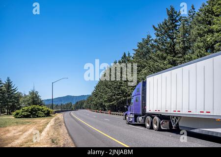 Purple Industrial Big Rig Semi-Truck mit LKW-Fahrer Kabine Schlafraum Transport von Fracht in trockenen van Sattelauflieger läuft auf Sommer-Autobahn Straße Stockfoto