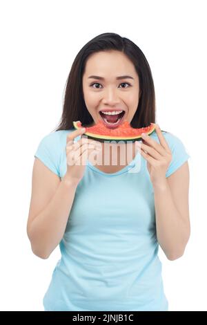 Porträt einer glücklichen, aufgeregten Vietnameswse-jungen Frau, die Wassermelone isst Stockfoto